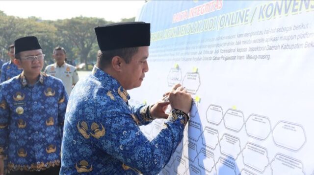 Pj Bupati Bekasi Dani Ramdan bersama Sekda Dedy Supriyadi dan seluruh kepala perangkat daerah menandatangani komitmen bersama menolak judi online, usai Upacara Korpri di Plaza Pemda, Cikarang Pusat, pada Rabu (17/07)