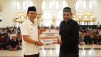 Pj Bupati Bekasi Dani Ramdan menyerahkan bantuan kepada 1.946 imam dan marbot di Masjid Izzatul Islam, Grand Wisata Tambun Selatan, Kabupaten Bekasi, Rabu (10/07).