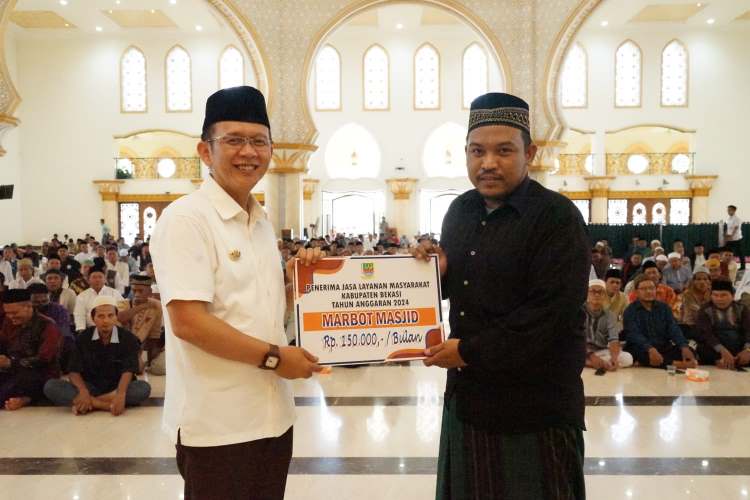 Pj Bupati Bekasi Dani Ramdan menyerahkan bantuan kepada 1.946 imam dan marbot di Masjid Izzatul Islam, Grand Wisata Tambun Selatan, Kabupaten Bekasi, Rabu (10/07).