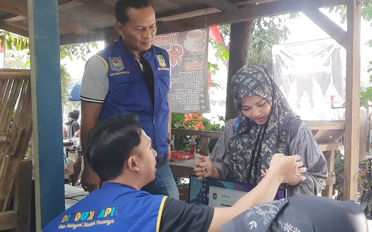 Salah seorang warga Desa Hegarmukti saat melakukan aktivasi Identitas Kependudukan Digital (IKD) di stand layanan adminduk Kecamatan Cikarang Pusat di tengah acara Hajat Bumi di Situ Rawa Binong, Sabtu (03/08).