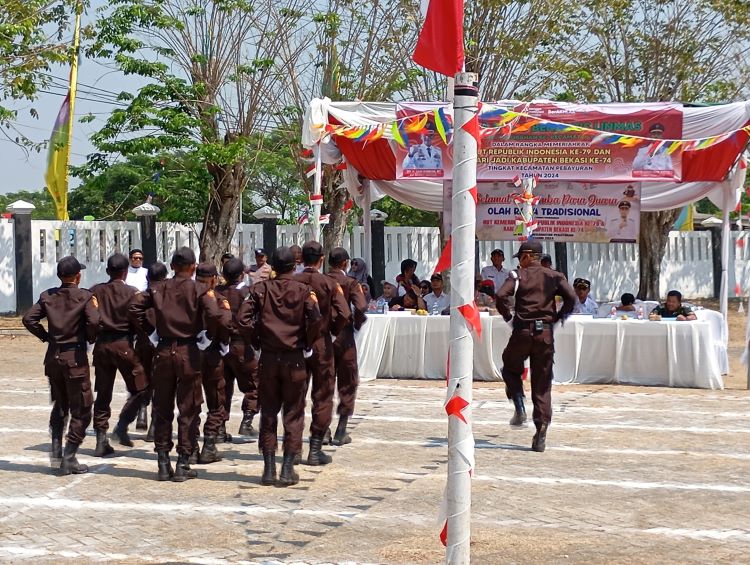 Anggota Satuan Perlindungan Masyarakat (Sat Linmas) dari 12 desa dan 1 kelurahan mengikuti lomba baris berbaris yang digelar di Lapangan Kantor Kecamatan Pebayuran pada Rabu (14/08).