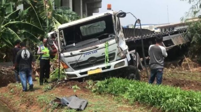 Satu unit truk kontainer pengangkut peti kemas bermuatan limbah kertas,  terjun bebas dari simpang susun Telaga Asih Tol Cibitung - Cilincing, Kecamatan Cikarang Barat, Kabupaten Bekasi, Senin (09/09).