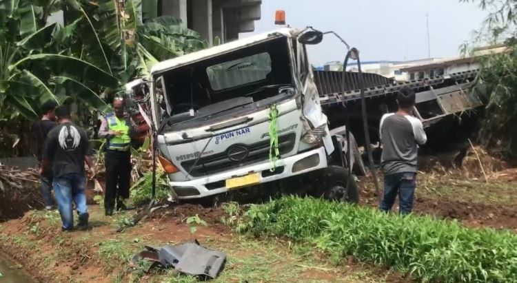 Satu unit truk kontainer pengangkut peti kemas bermuatan limbah kertas,  terjun bebas dari simpang susun Telaga Asih Tol Cibitung - Cilincing, Kecamatan Cikarang Barat, Kabupaten Bekasi, Senin (09/09).