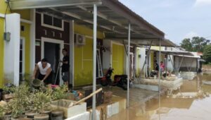 Banjir di Perumahan The Arthera Hill, Desa Jayasampurna, Kecamatan Serang Baru, Kabupaten Bekasi surut. Warga membersihkan lumpur pasca banjir, Selasa (19/11),