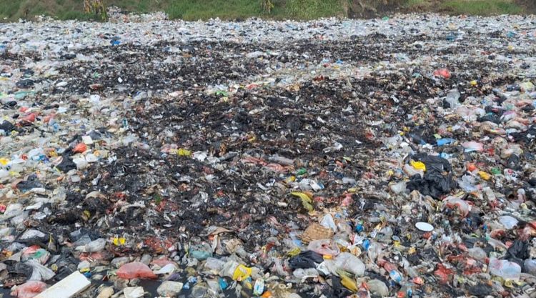 Hamparan sampah yang teronggok di tengah sawah di Desa Muarabakti, Kecamatan Babelan. Sampah-sampah tersebut diduga sengaja dibuang di lokasi tersebut oleh pihak tak bertanggung jawab.