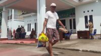 Salah seorang warga saat membawa pulang paket sembako murah dalam acara Gerakan Pangan Murah (GPM) di di Desa Sukasejati, Kecamatan Cikarang Selatan, Kabupaten Bekasi, Senin (02/12).