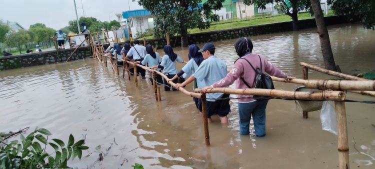 Ratusan buruh yang bekerja di Kawasan Industri EJIP, Cikarang Selatan, Kabupaten Bekasi, harus menghadapi situasi berbahaya. Mereka terpaksa melintasi jembatan bambu selebar satu meter yang kini terendam banjir akibat meluapnya aliran saluran irigasi yang bermuara ke Kali Cikarang.