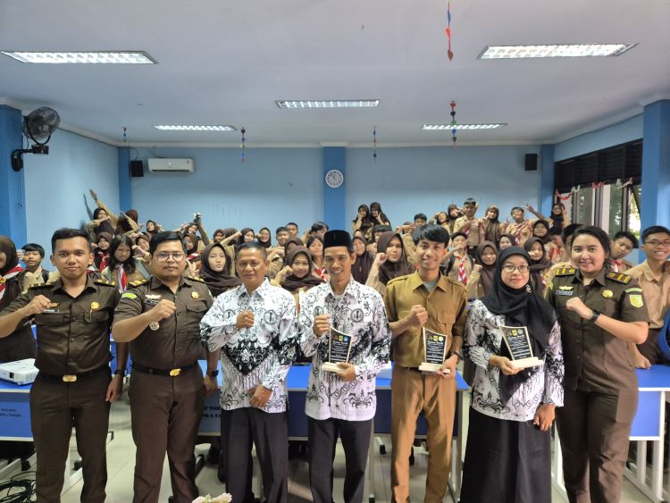 Kepala Subseksi I pada Seksi Intelijen, Emanuel Wisnu bersama Jaksa Fungsional, Evy Putri dan Jefferson Hakim foto bersama ratusan pelajar yang berasal dari SMPN 4 Tambun Selatan, SMPN 9 Tambun Selatan, dan SMPN 14 Tambun Selatan beserta tenaga pendidik sekolah-sekolah tersebut pada kegiatan Jaksa Masuk Sekolah, Selasa (25/02). 