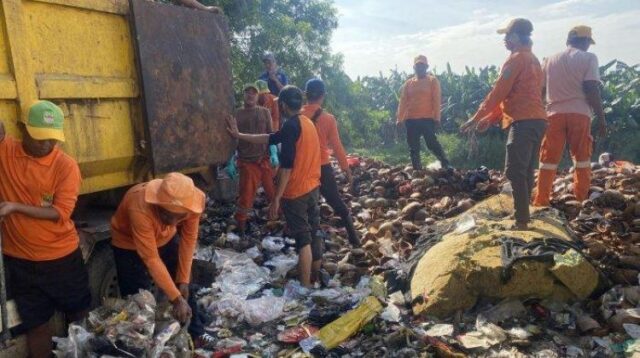 Puluhan orang petugas kebersihan dikerahkan untuk membersihkan tumpukan sampah di bantaran Kali CBL, Kamis (24/04).