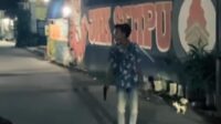 Dalam video berdurasi 54 detik yang tersebar luas, terlihat seorang pemuda mengenakan baju bermotif kembang dan celana jeans putih kedapatan membawa diduga senjata api jenis pitol.