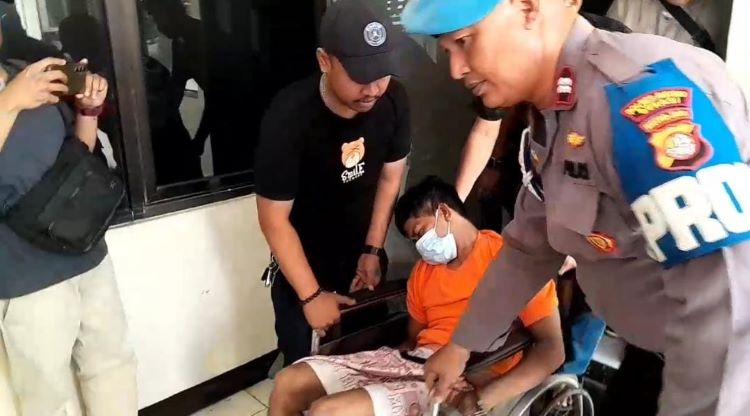 Pelaku pelecahan seksual terhadap anak, SA (32) mencoba mengelabui publik dengan berpura-pura tidur di kursi roda saat polisi menggelar konferensi pers terkait kasus yang menjeratnya. SA, yang berprofesi sebagai badut keliling, terlihat duduk lemas di atas kursi roda dengan mata terpejam seolah-olah sedang sakit parah.