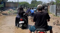 Warga Kecamatan Cibitung, Kabupaten Bekasi, mengungkapkan kekesalannya terkait proyek pembangunan Jalan Raya Kali Cikarang Bekasi Laut (CBL) di Desa Sukajaya yang belum selesai hingga kini. Kondisi jalan yang rusak parah dan dipenuhi genangan air membuat aktivitas warga terganggu, terutama bagi pengendara roda dua.