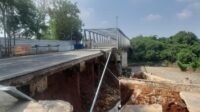 Timbunan jalan pendekat Jembatan Cipamingkis yang terletak di Desa Sirnajati, Kecamatan Cibarusah, Kabupaten Bekasi, mengalami kerusakan parah setelah tergerus aliran Kali Cipamingikis pada Senin (08/07) malam. Akibatnya, akses penghubung antara Desa Cibarusah Kota dengan Sirnajati terputus total.