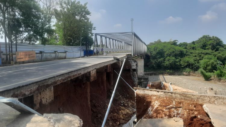 Timbunan jalan pendekat Jembatan Cipamingkis yang terletak di Desa Sirnajati, Kecamatan Cibarusah, Kabupaten Bekasi, mengalami kerusakan parah setelah tergerus aliran Kali Cipamingikis pada Senin (08/07) malam. Akibatnya, akses penghubung antara Desa Cibarusah Kota dengan Sirnajati terputus total.
