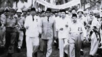 Mohamad Hasyim Achmad (sebelah kiri Presiden Sukarno) saat mendampingi Presiden Sukarno dalam Rapat Akbar di Alun-alun Bekasi bersama Madmuin Hasibuan (paling kanan) dan Bupati Bekasi, Sampurno Kolopaking (baju putih berdasi) pada 8 April 1956. Foto : ist.