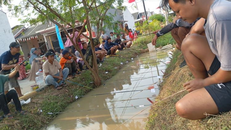 Ratusan warga RT 052 RW 013 Perumahan Cikarang Utama Residence, Desa Jayasampurna, Kecamatan Serang Baru saat mengikuti lomba mancing ikan di parit dalam rangka perayaan HUT ke-80 Kemerdekaan Republik Indonesia.