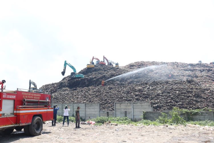 Ribuan liter cairan mikroba disemprotkan menggunakan dua unit mobil pemadam kebakaran untuk menjangkau area sampah di TPA Burangkeng yang berada di ketinggian.