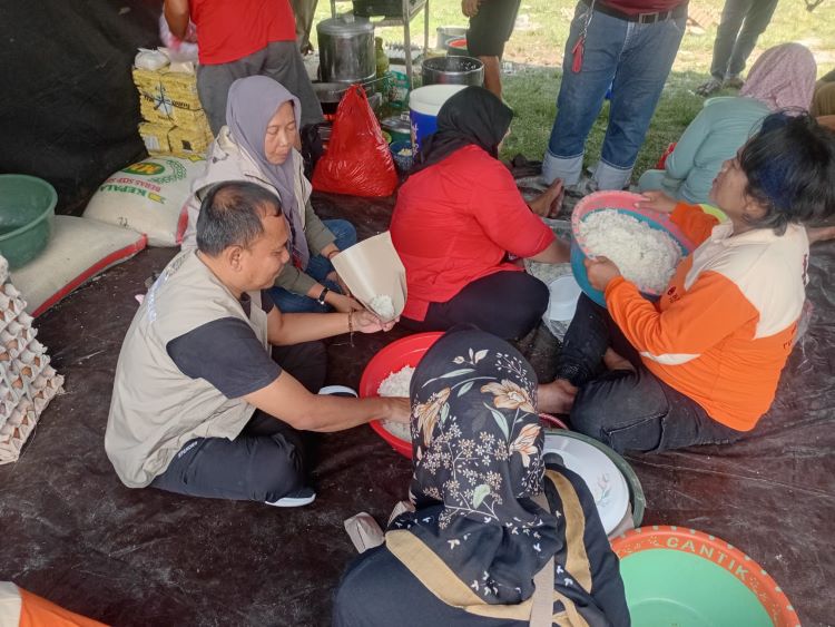 Sekretaris DPC PDI Perjuangan Kabupaten Bekasi, Usup Supriatna turut membantu menyiapkan makanan siap santap untuk warga terdampak banjir di dapur umum Baguna yang terletak di Desa Karang Asih, Kecamatan Cikarang Utara, Kabupaten Bekasi, Senin (03/11).