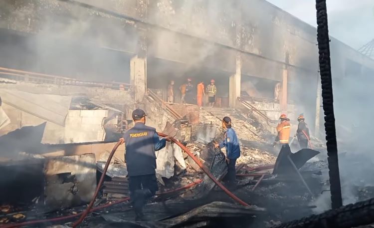 Petugas Pemadam Kebakaran Kabupaten Bekasi saat melakukan pendinginan di area Pasar Baru Cikarang yang terbakar, Selasa (04/11) pagi.