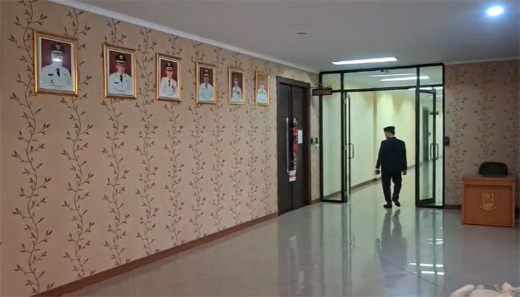 Salah seorang aparatur sipil negara (ASN) Pemkab Bekasi melintas di depan ruang kerja Bupati Bekasi yang disegel oleh KPK, Jum'at (19/12) pagi.