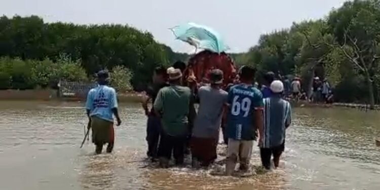 Potret perjuangan warga Kp Beting, Desa Pantai Bahagia, Kecamatan Muaragembong, Kabupaten Bekasi saat menerjang air setinggi lutut hingga paha akibat banjir rob demi memakamkan salah seorang warga yang meninggal dunia.