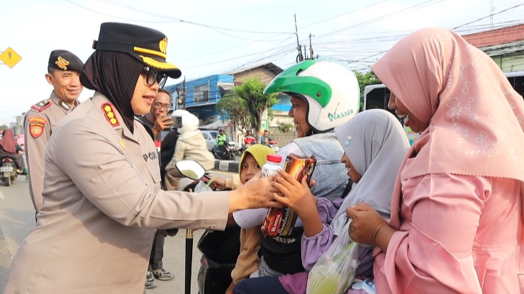 Kapolres Metro Bekasi, Kombes Sumarni saat membagikan biskuit dan susu kepada pengendara roda dua yang melintas di depan Pos Terpadu Gedung Juang 45 Tambun Selatan, Kabupaten Bekasi, Senin (23/03).
