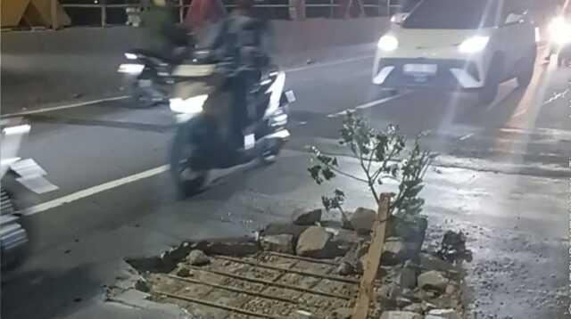 Kondisi lubang di Flyover Tegal Gede Desa Pasirsari, Kecamatan Cikarang Selatan, Kabupaten Bekasi, Kamis (07/05) malam. Warga memasang batang pohon sebagai penanda agar pengendara lebih berhati-hati saat melintas.