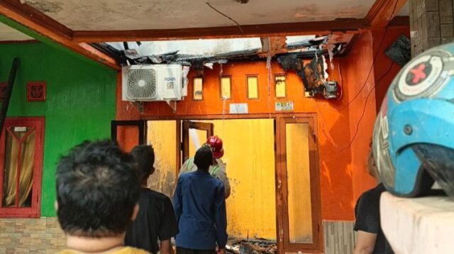 Petugas dari Dinas Pemadam Kebakaran & Penyelamatan Kabupaten Bekasi melakukan proses pendinginan di rumah yang terbakar.