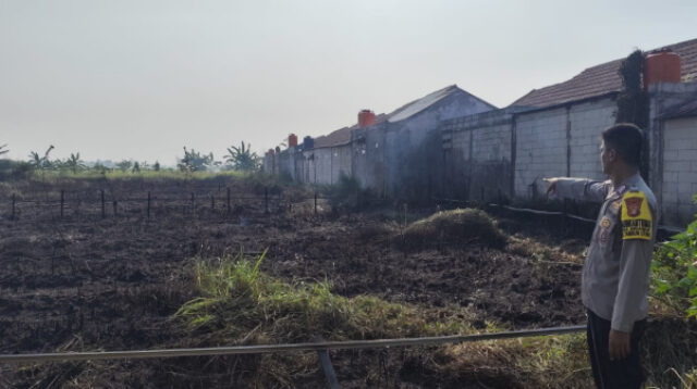 Binmaspol Desa Sriamur saat mengecek area alang-alang di wilayah RT 08 RW 03, Desa Sriamur, Kecamatan Tambun Utara, Kabupaten Bekasi yang terbakar, Jumat (10/07) siang.