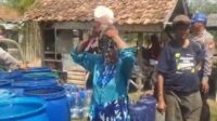 Seorang warga di Kampung Jereged, Desa Nagasari, Kecamatan Serang Baru, spontan mandi menggunakan air bersih dari mobil tangki saat bantuan air dari Polsek Serang Baru tiba, Senin (13/07).