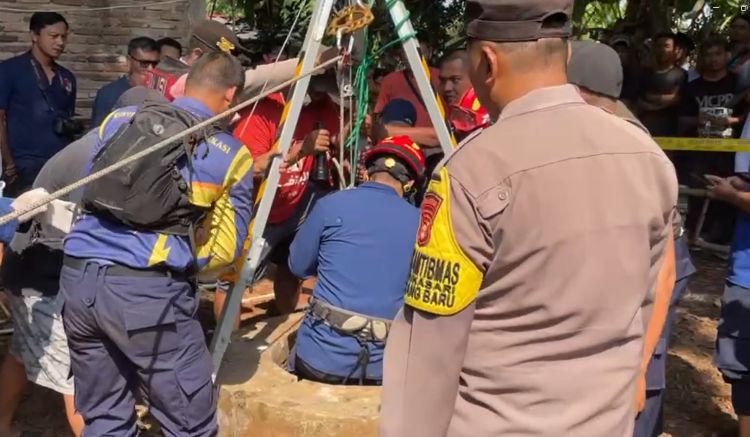 Petugas dari Tim Rescue Dinas Pemadam Kebakaran dan Penyelamatan (Disdamkarmat) Kabupaten Bekasi dan unsur terkait saat melakukan evakuasi korban yang terjatuh ke dalam sumur di di Kampung Babakan RT 013/006, Desa Sukasari, Kecamatan Serang Baru, Kabupaten Bekasi, Jumat (10/07).