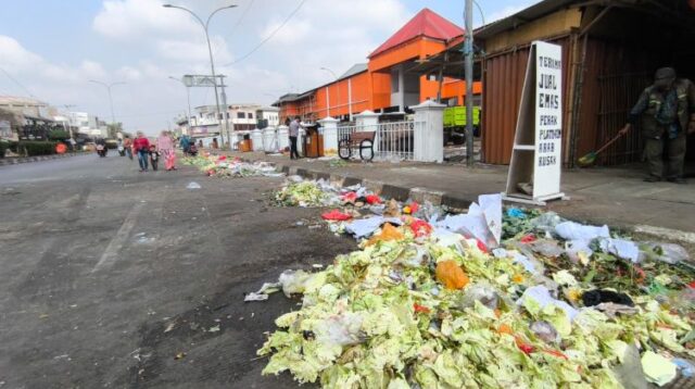 sampah berupa sisa sayuran dan limbah dagangan berserakan di badan jalan depan Pasar Baru Cikarang, Senin (03/08) siang.