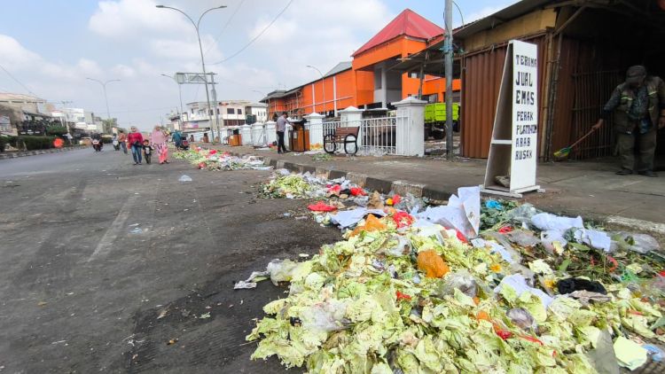 sampah berupa sisa sayuran dan limbah dagangan berserakan di badan jalan depan Pasar Baru Cikarang, Senin (03/08) siang.