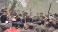 Sejumlah warga terlihat membawa bambu dan kayu yang digunakan sebagai alat untuk menghadang petugas saat hendak melakukan penertiban bangunan liar (bangli) di di Jalan Jarakosta, Desa Sukadanau, Kecamatan Cikarang Barat, Kabupaten Bekasi, Rabu (02/09).